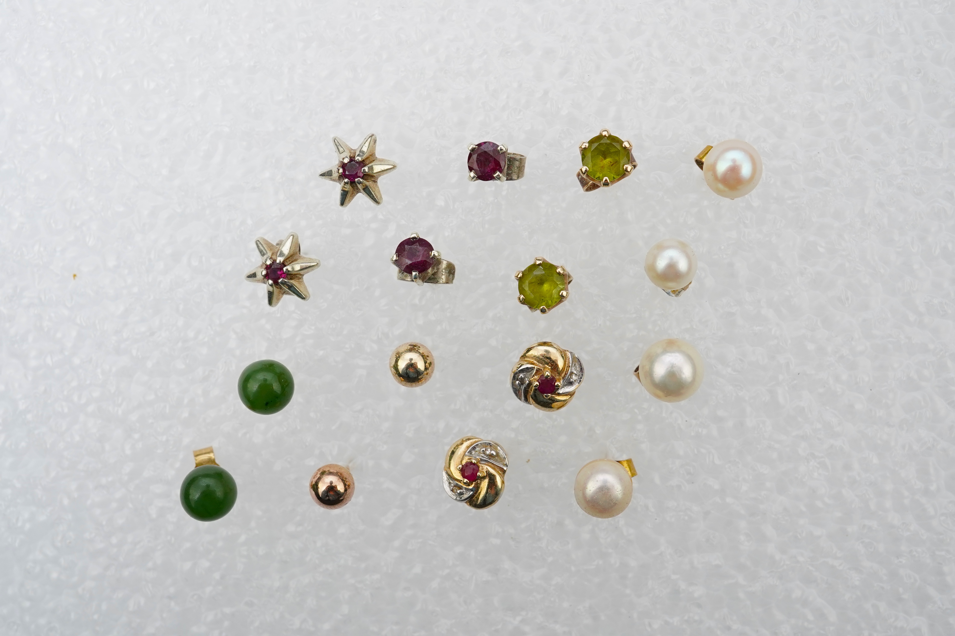 Four assorted pairs of 9ct and gem set ear studs including peridot and cultured pearl, together with three other assorted pairs yellow or white metal ear studs and two odd ear studs.